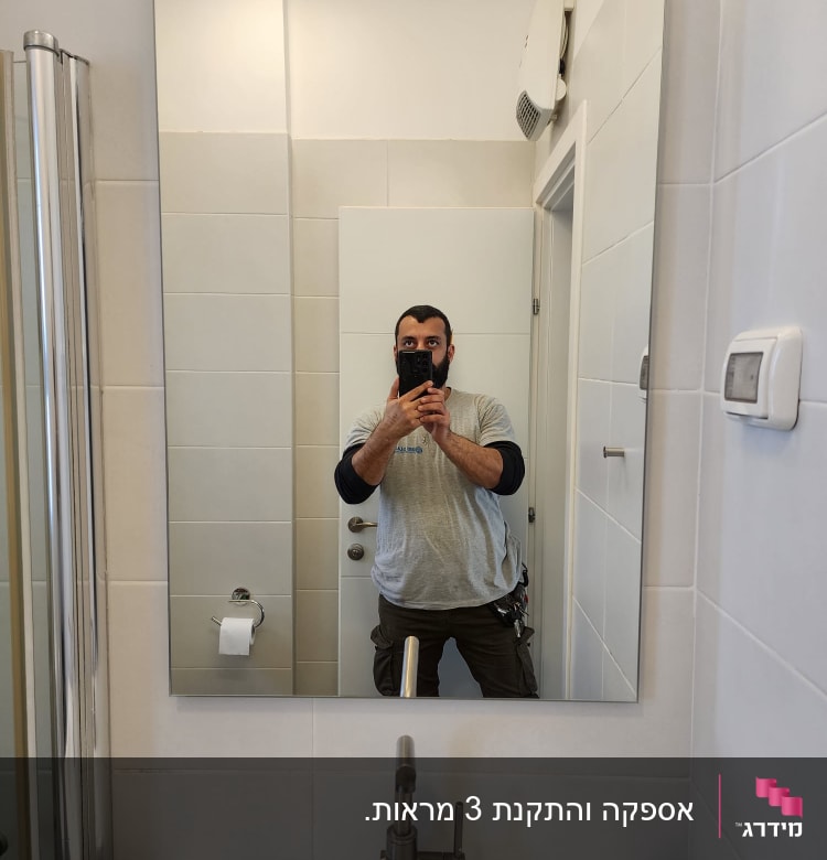 מראה תלויה על קיר בחדר אמבטיה